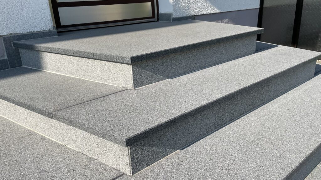 Graue Außentreppe zum Hauseingang. Solide und modern gestaltet. Steinmetz Meisterbetrieb