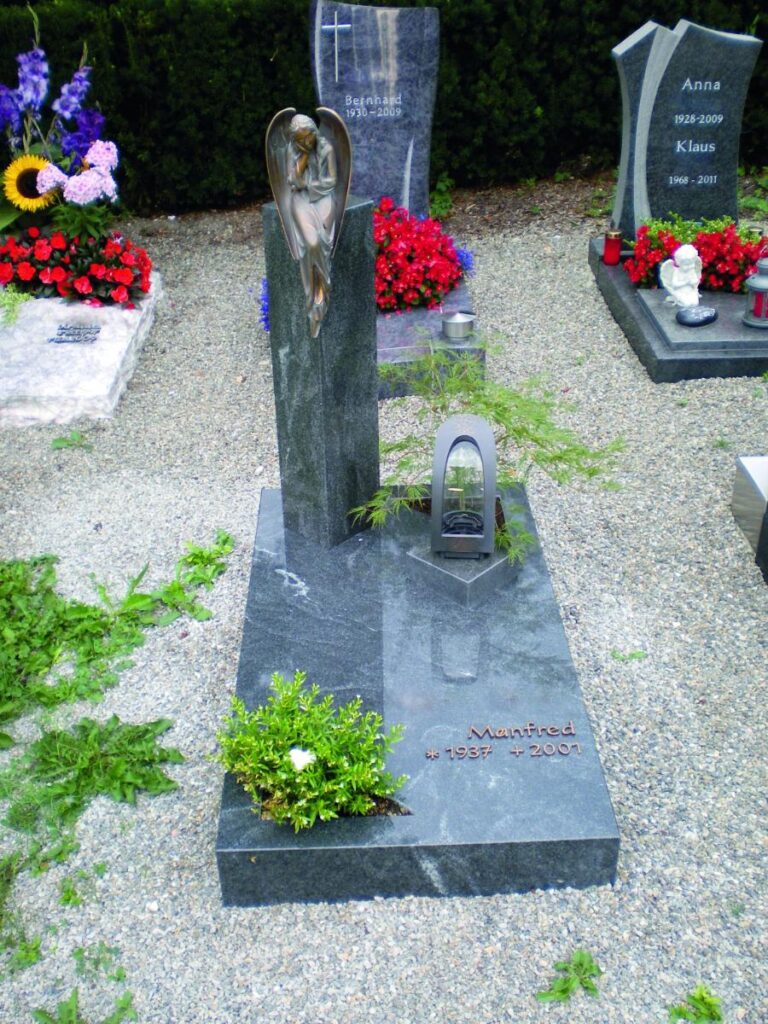 Grabsteine: Grab mit Engelstatue, Inschrift "Manfred *1937 +2001". Steinmetz Meisterbetrieb