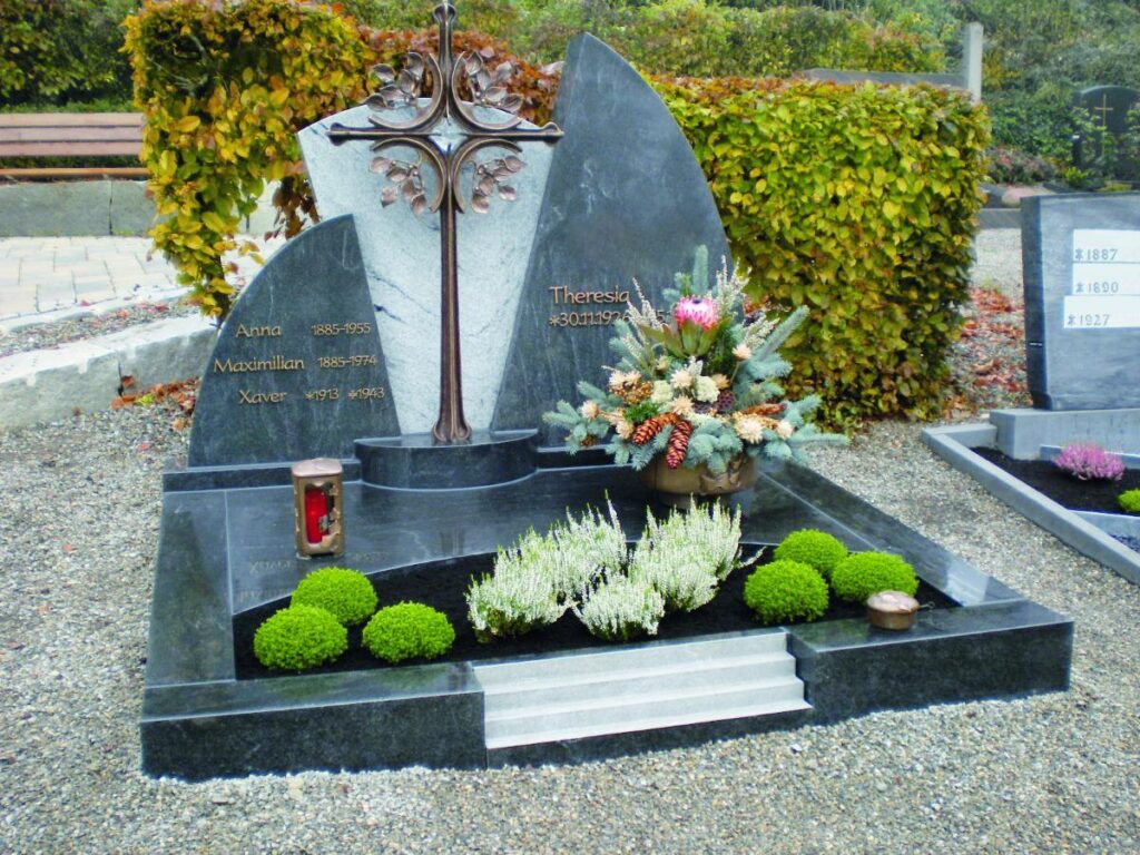 Grabstein mit Kreuz, Blumen und Inschriften: Anna, Theresia, Maximilian, Xaver. Friedhofsdekoration. Steinmetz Meisterbetrieb